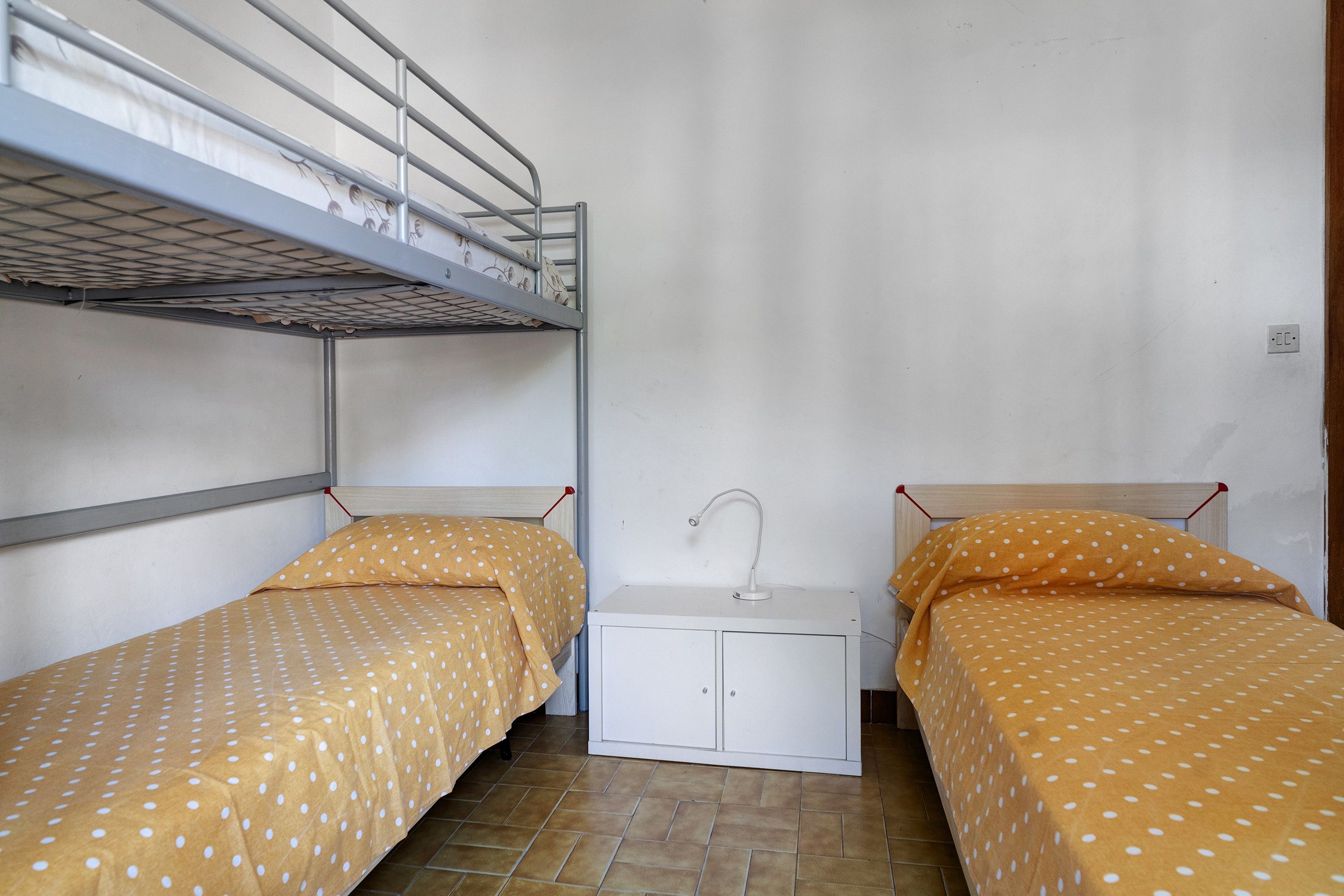 Una habitación pequeña y compacta con literas y una mesita de noche.
