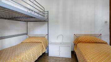 Una habitación pequeña y compacta con literas y una mesita de noche.