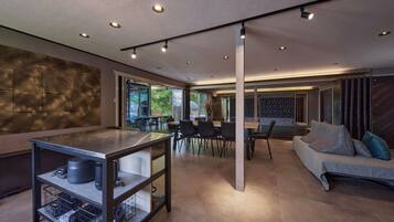 A modern interior with a dining area, a sofa, and a kitchen counter.