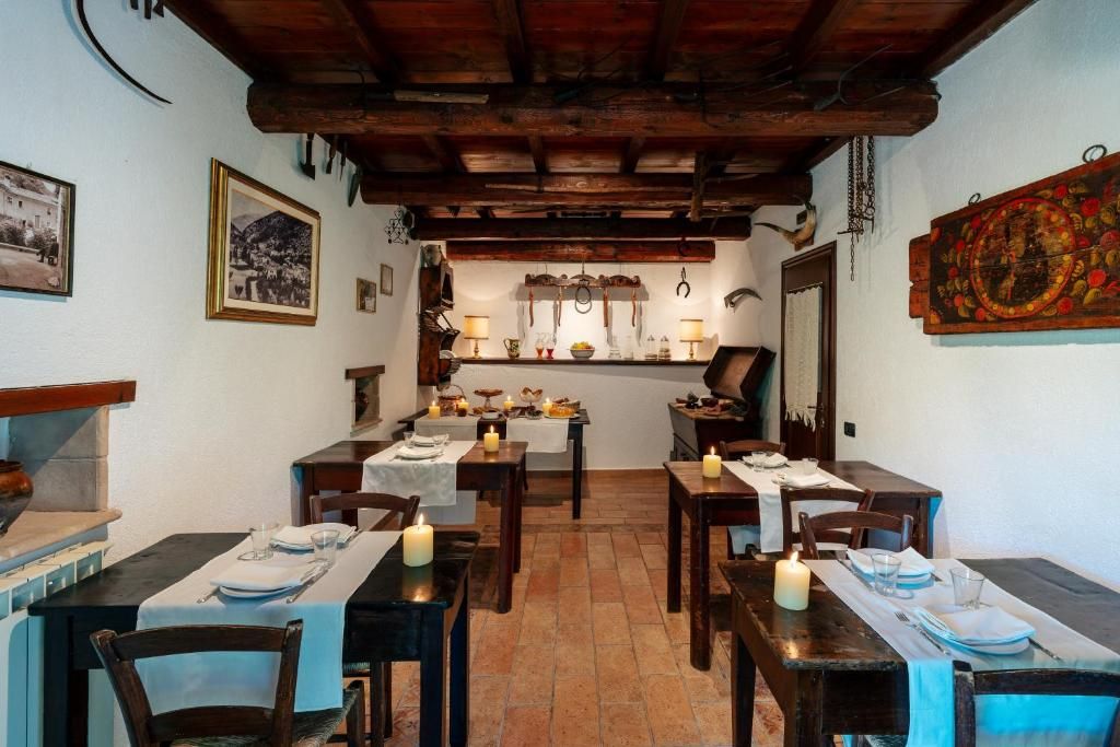 Un comedor con mesas y sillas de madera, y un ambiente iluminado por velas.