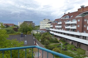 A residential building with multiple balconies, a courtyard with greenery, and a view of the sea. - Sparrow's Nest Pavilion (Cuxhaven)