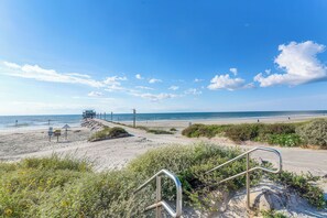 A coastal road leading to a beach with a lifeguard station and a clear view of the ocean. - Galveston Condo (Galveston)