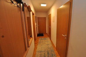 A hallway with wooden doors, a carpet, and a light fixture. - Holiday apartment with 1 bedroom (Schwangau)
