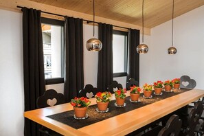 A long dining table with potted plants and heart-shaped chairs. - Holiday apartment with 2 bedrooms (Oberstdorf)
