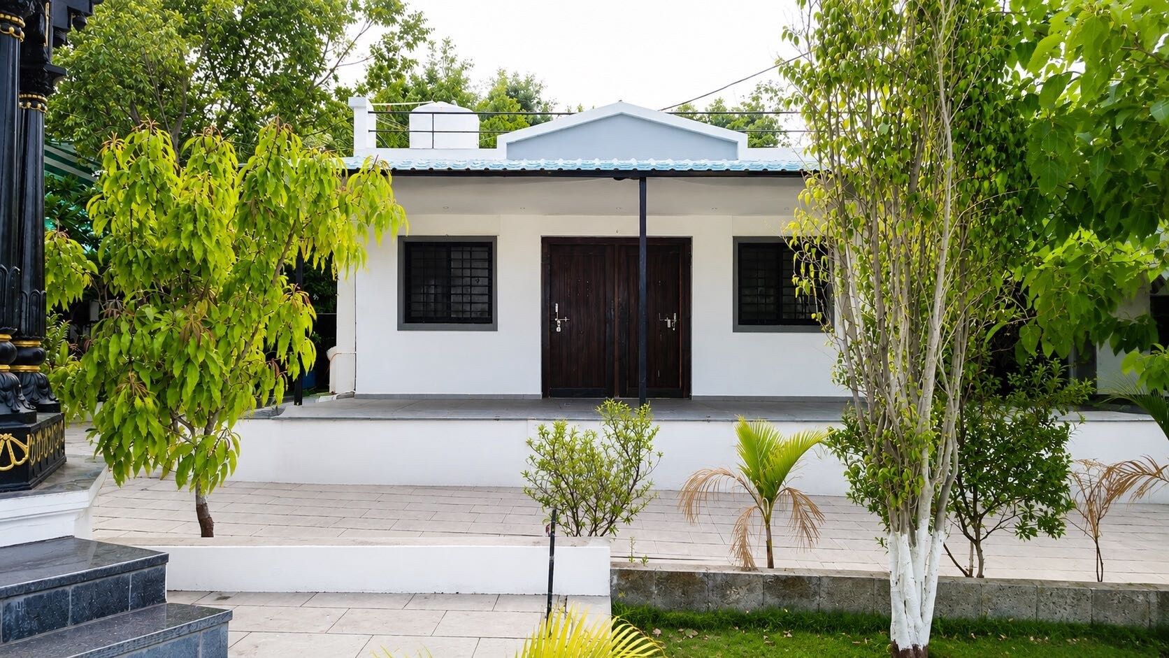 Un bâtiment moderne à deux étages, doté d’un toit plat, d’une entrée principale avec une porte sombre et d’un petit porche.