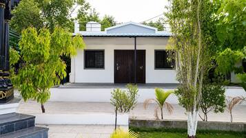Un bâtiment moderne à deux étages, doté d’un toit plat, d’une entrée principale avec une porte sombre et d’un petit porche.