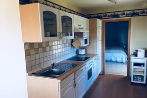 Eine kleine Küche mit Mikrowelle, Toaster und Spüle.
