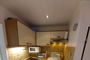 A compact kitchen with a microwave, toaster, and kettle. - Mövennest, holiday apartment 2 in the Süderhaus (Borkum)