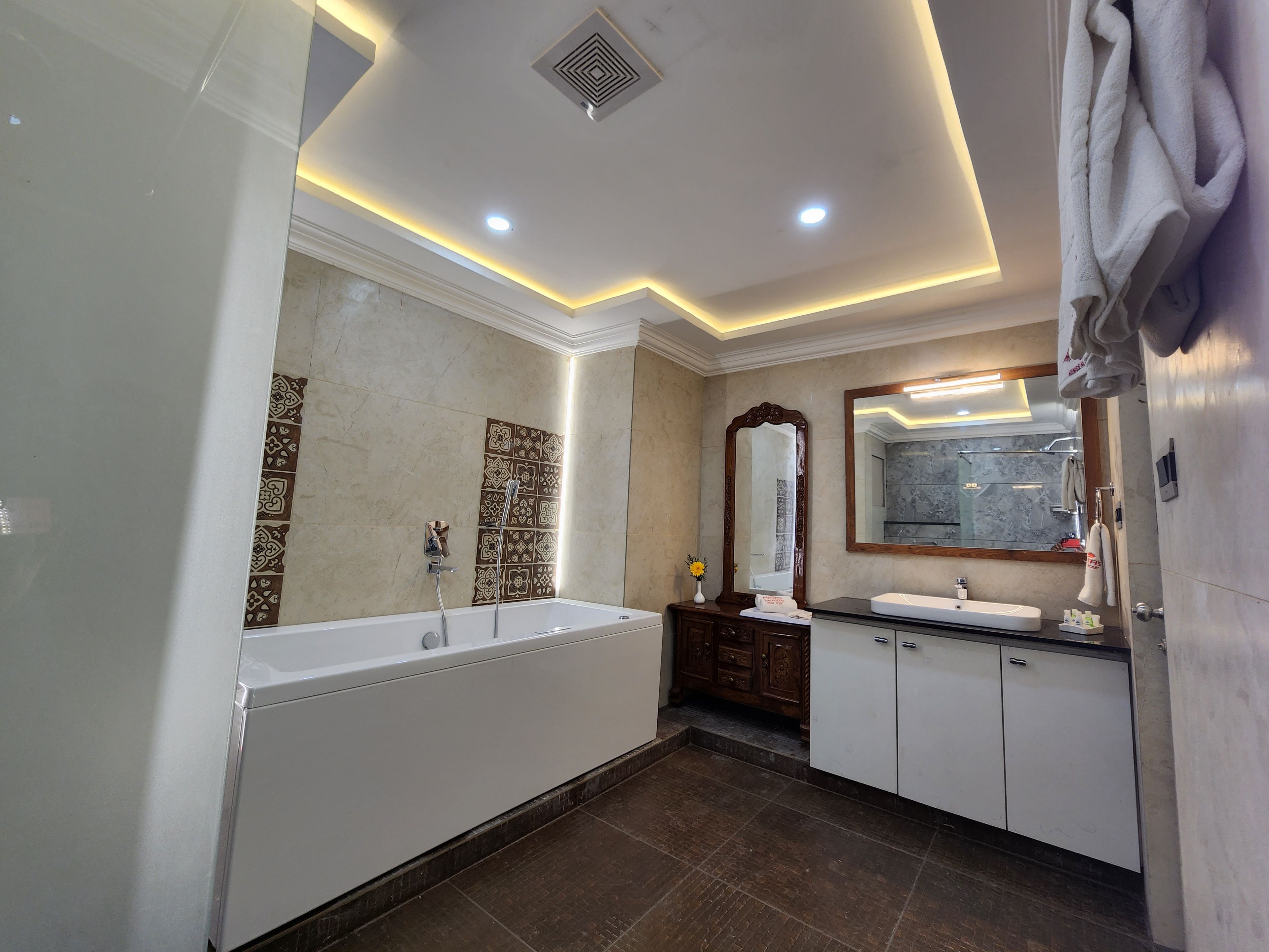Un baño moderno con bañera, ducha y tocador con espejo.
