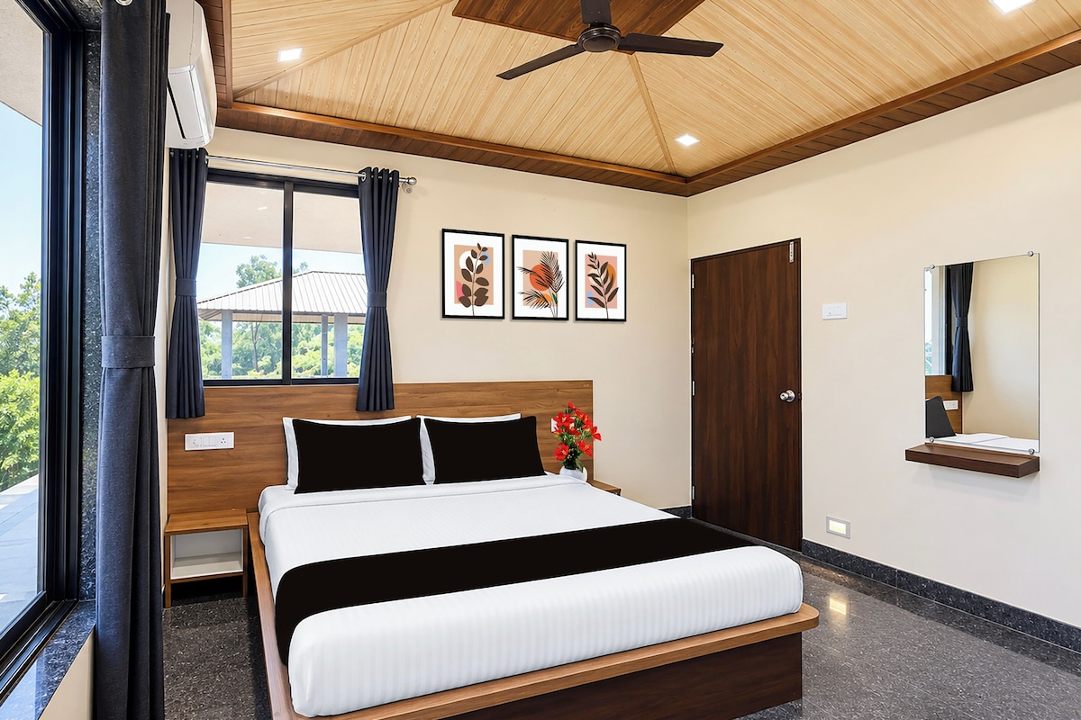 A modern bedroom with a large bed, a ceiling fan, a window with curtains, and artwork on the wall.