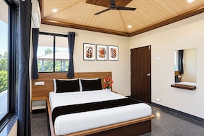 A modern bedroom with a large bed, a ceiling fan, a window with curtains, and artwork on the wall. - Collection O Parsi Point Mahabaleshwar (Mahabaleshwar)