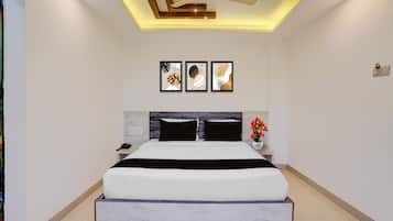 A modern bedroom with a bed, bedside tables, a ceiling fan, and wall art.