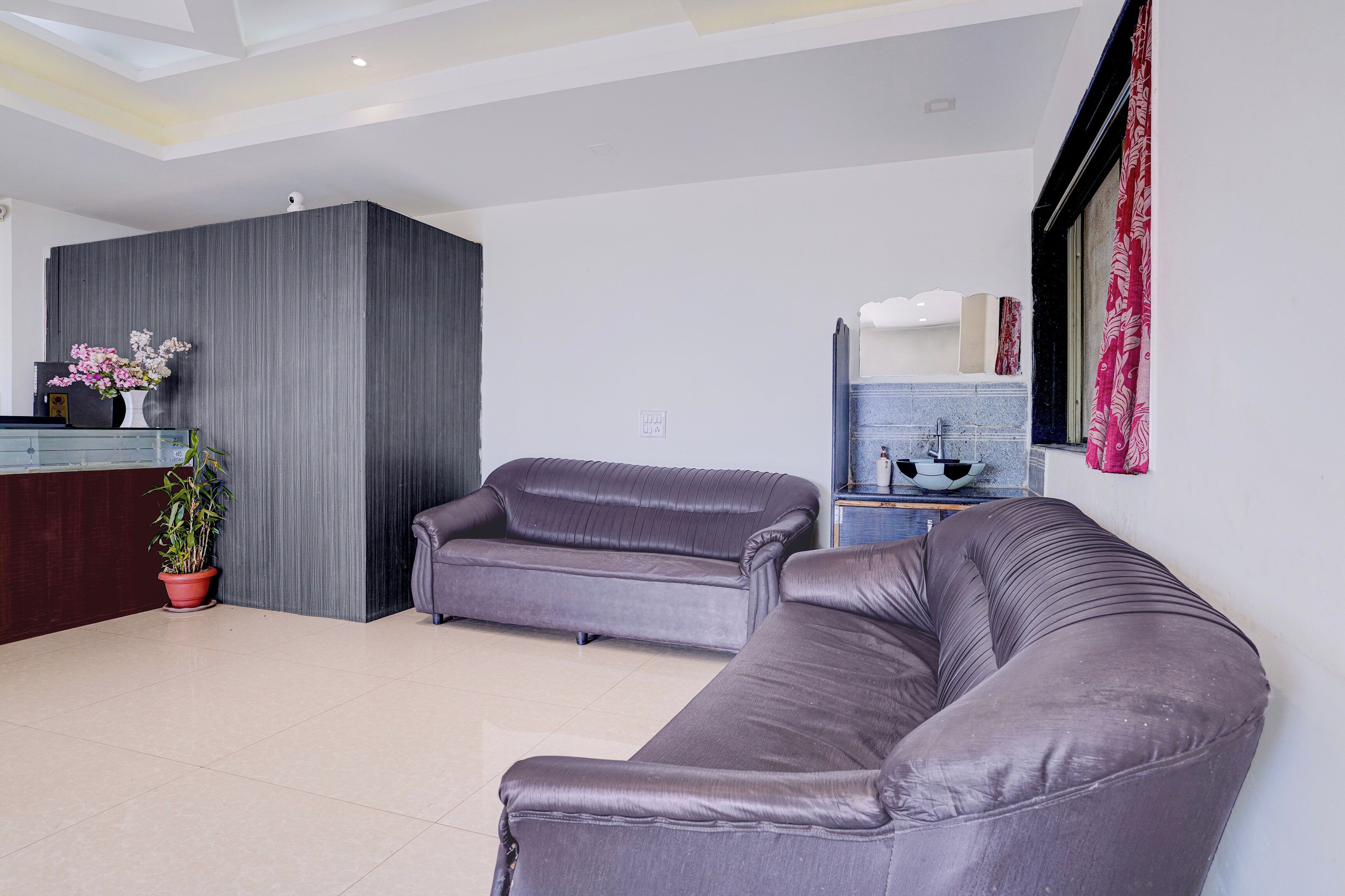A modern living room with a sofa, a small table, and a potted plant.