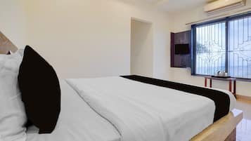 Un dormitorio moderno con cama, televisor montado en la pared y ventana con vistas.