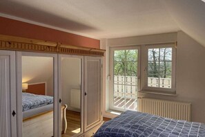 A bedroom with a large window, a balcony, and a wardrobe. - Country House Maarweg (Loquard)