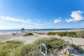 A beach with a lifeguard tower, a sandy path, and a clear blue sky. - Galveston Condo - 2nd-Floor Coastal Retreat with a Shared, Year-Round Heated Pool (Galveston)
