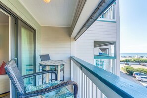 A balcony with a view of the ocean and parked cars. - Galveston Condo - 2nd-Floor Coastal Retreat with a Shared, Year-Round Heated Pool (Galveston)
