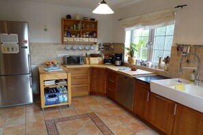 A kitchen with a refrigerator, microwave, coffee maker, and a sink. - Holiday home in Juist with swimming pool (Juist)