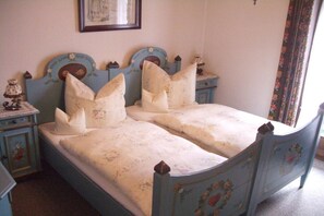 Een slaapkamer met een tweepersoonsbed, twee nachtkastjes en een kaptafel.