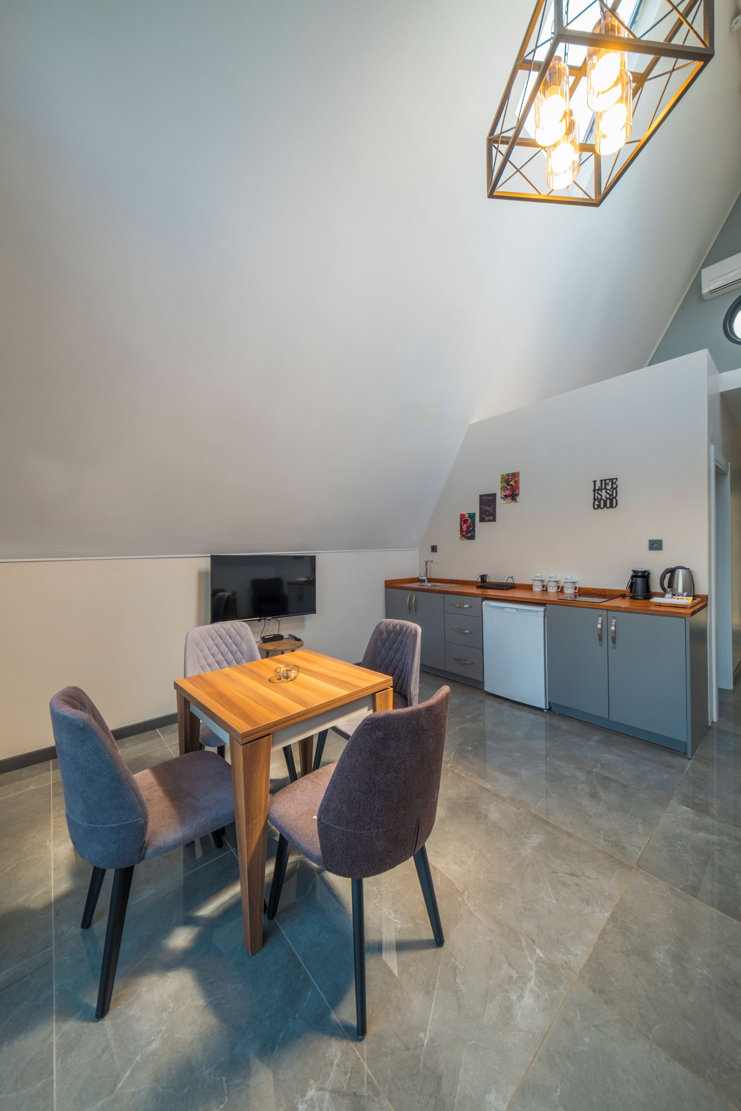 Una cocina moderna con encimera de madera, armarios grises y horno empotrado.