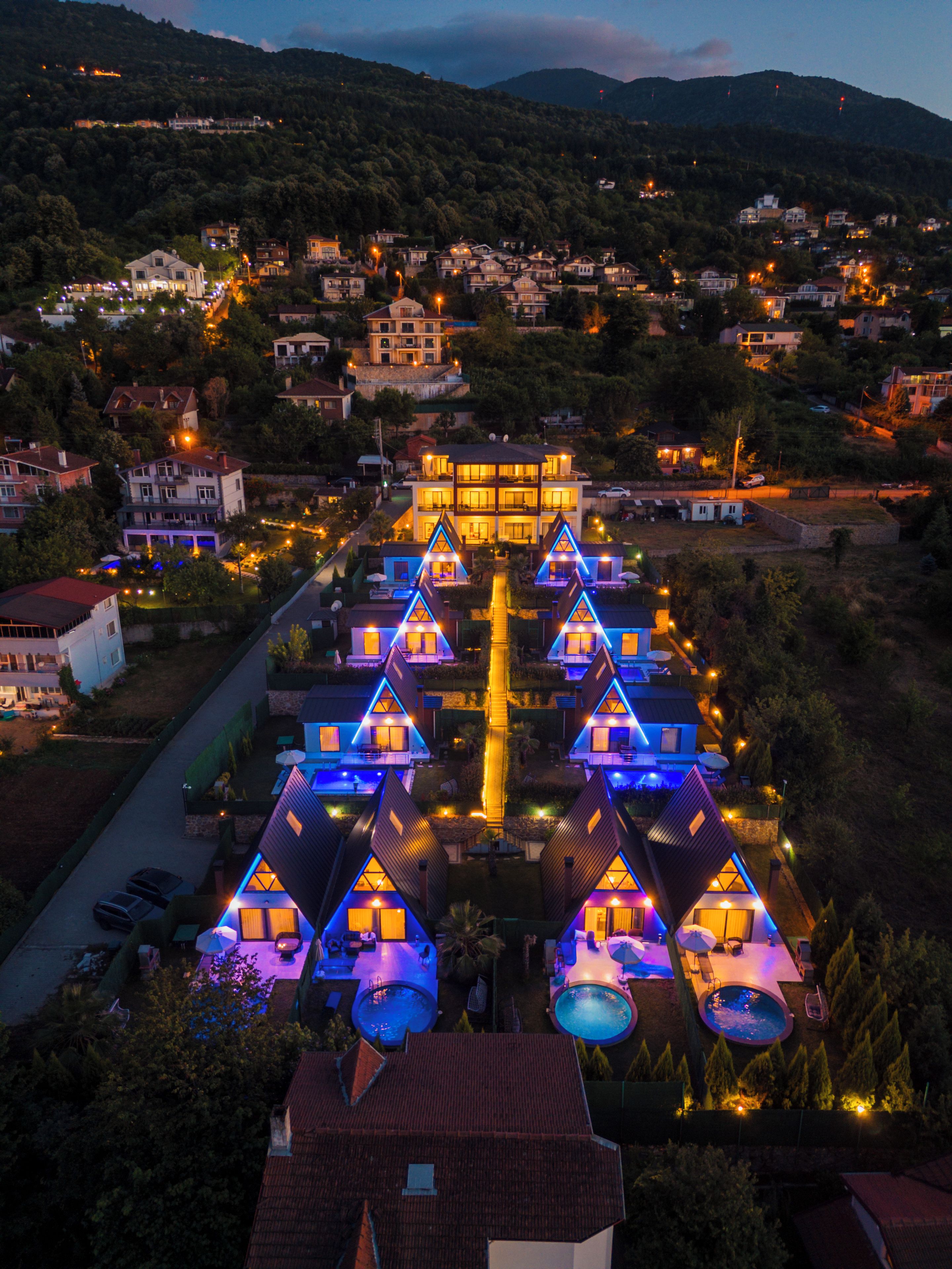 A resort with multiple villas, a central pool, and a mountain backdrop.