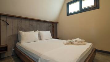 Un dormitorio con cama, mesita de noche, ventana y lámpara de techo.