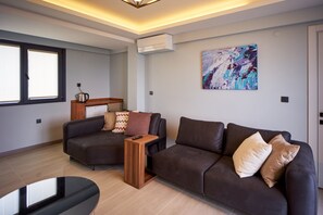 A modern living room with a sofa set, a coffee table, and a painting on the wall.