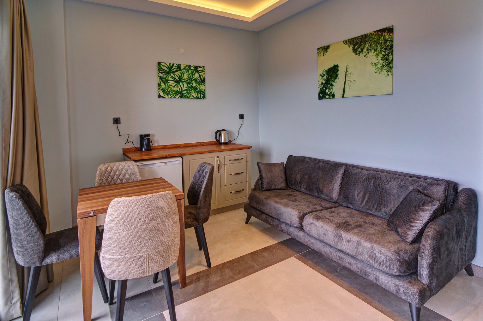 Un espacio habitable funcional con kitchenette, comedor y sofá.