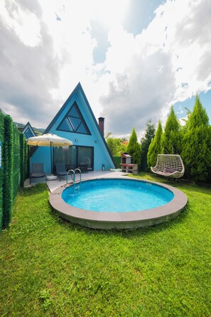 A swimming pool with a triangular building in the background.