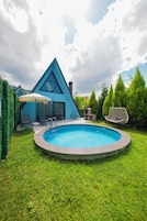 Piscina com um edifício triangular ao fundo.
