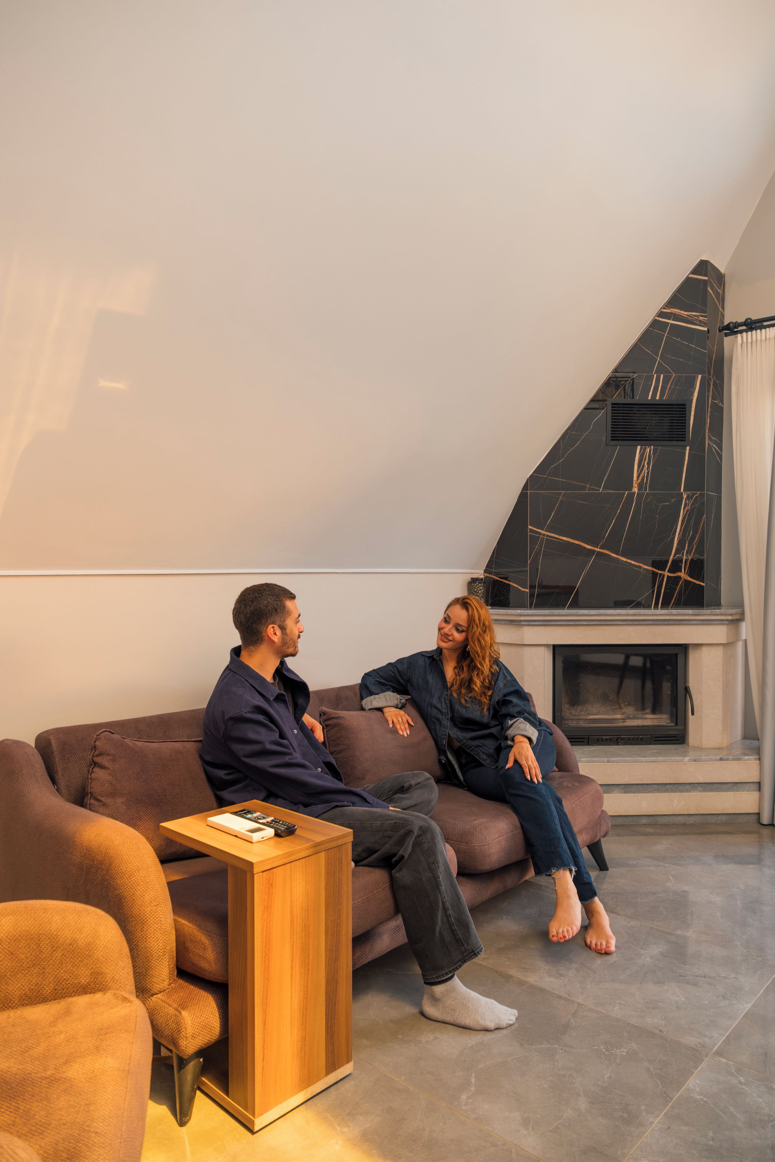 A modern living room with a sofa, a coffee table, and a fireplace.