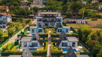 Un ensemble résidentiel comprenant plusieurs maisons à deux étages, un chemin central et une piscine.