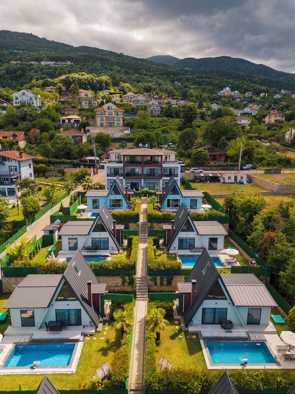 A residential complex with multiple two-story houses, a central pathway, and a swimming pool.