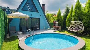 Una casa moderna con piscina, mobiliario exterior y cielo despejado.