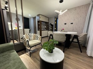 A modern living room with a round table, two chairs, a sofa, and a decorative plant. - Fontana Country Set (Ibagué)