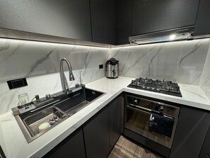 A modern kitchen with a stainless steel sink, a built-in stove, and a coffee maker. - Fontana Country Set (Ibagué)