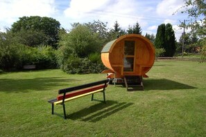 A wooden barrel-shaped structure with a bench in front. - Dog holiday home Derber (Mohrweiler)