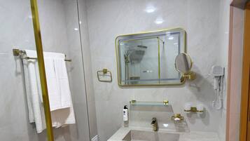 Ein modernes Badezimmer mit einer Duschkabine, einem Waschtisch mit Spiegel und einer Toilette.
