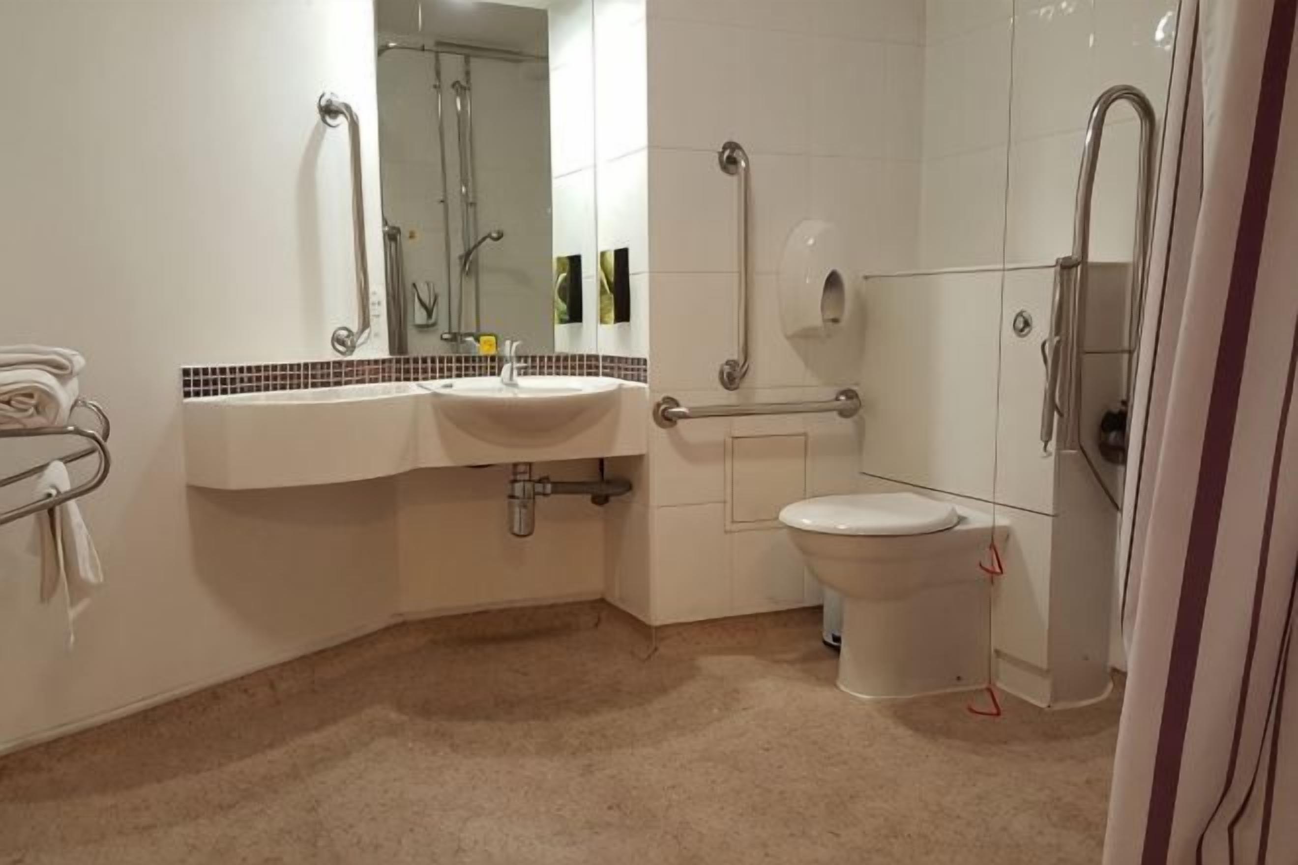 Een badkamer met een wastafel, toilet en douche.