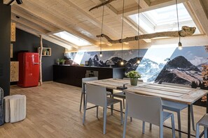Eine moderne Küche mit einer großen Kochinsel, Holzboden und einem Wandbild mit Bergblick.