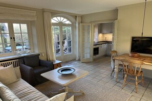 Un salon confortable avec un canapé, une petite table et une cuisine en arrière-plan.