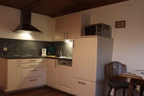 A compact kitchen with a microwave, a sink, and a dishwasher. - at the country house Heel (Schwangau)