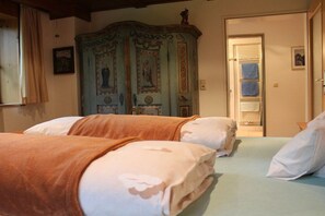 A bedroom with two beds, a wardrobe, and a door leading to a bathroom. - at the country house Heel (Schwangau)