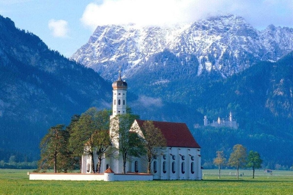En kirke med et kirketårn og et slot i baggrunden.