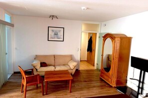 A living room with a sofa, a wooden table, and a wooden cabinet.