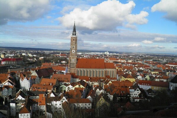 A historic town with a prominent clock tower, red-roofed buildings, and a large church. - Apartment in Landshut with swimming pool (Landshut)
