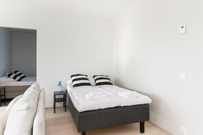 Un dormitorio moderno con cama, mesita de noche y zona de escritorio.