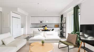 Uma sala de estar moderna com um sofá, uma mesa de centro e uma televisão.