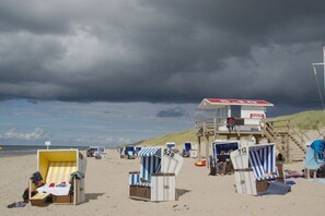 A beach with beach chairs and a lifeguard tower. - "Syltperle" in the Sölring-Hüs (Sylt\/Rantum)