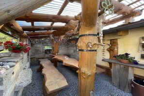 Eine hölzerne Außenanlage mit Bänken, Tischen und Steinmauern im rustikalen Stil.